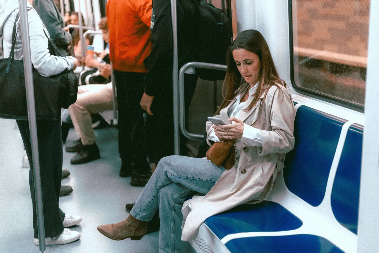 A woman on a train looking at a phone