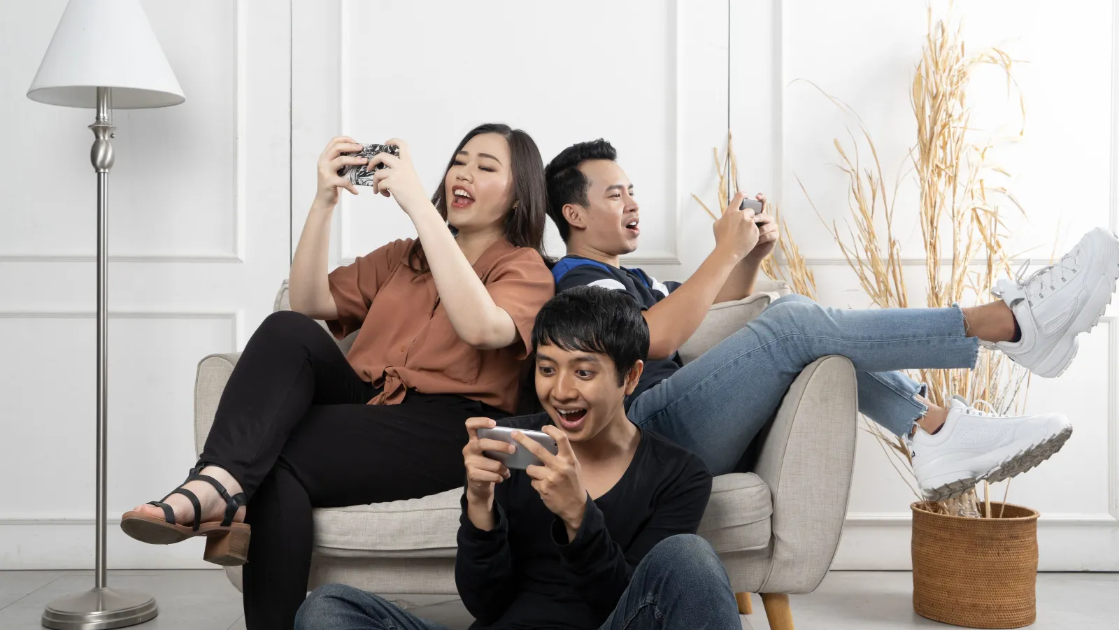 Three friends playing games on their phones