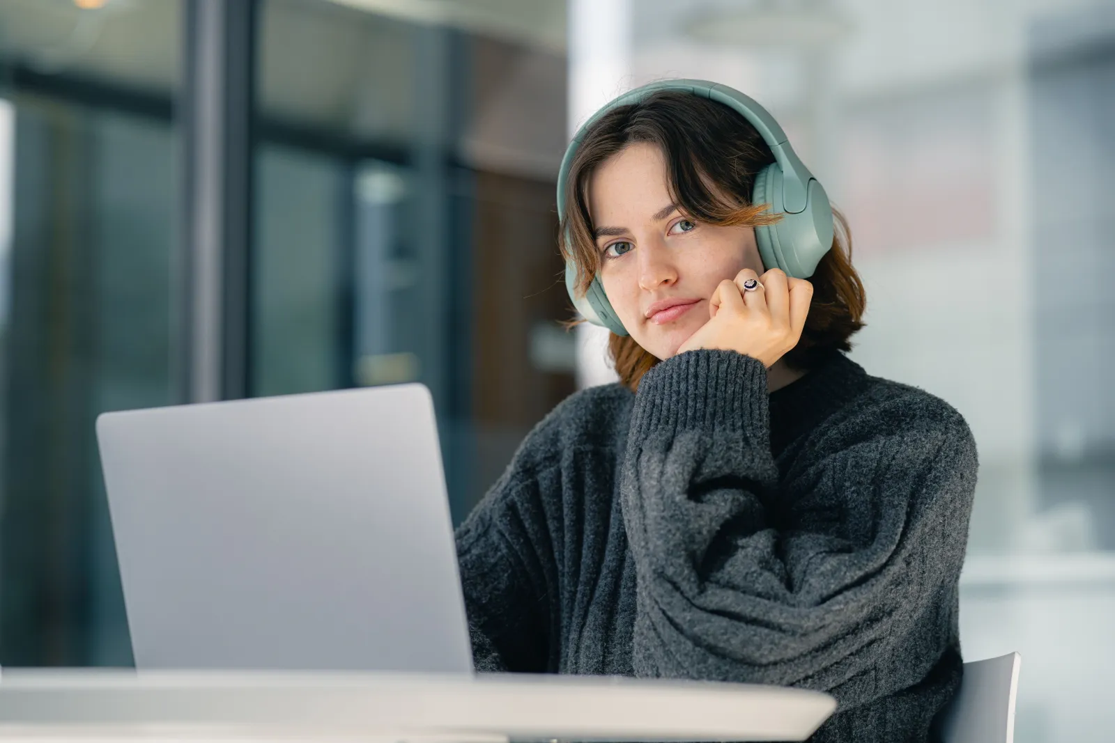 A researcher with headphones following an interview on a laptop